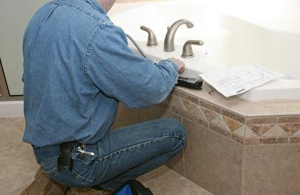 a plumber is repairing a leaky faucet in the bathroom