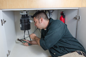 Lenny is repairing a broken garbage disposal