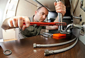 a plumber in Suitland is repairing a kitchen drain